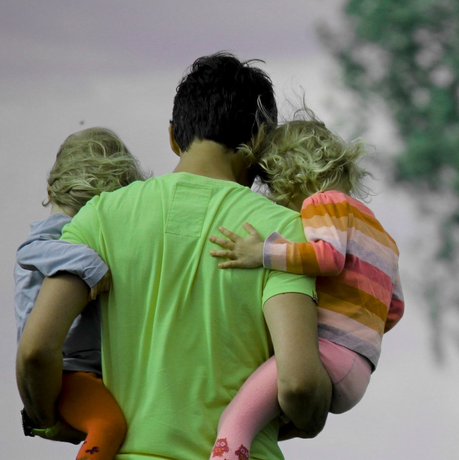 Dúas persoas en bicicleta nun parque, polo contexto pai e fillo