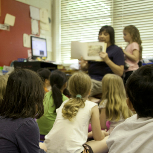 Unha profesora lendo un conto nunha aula chea de nenos